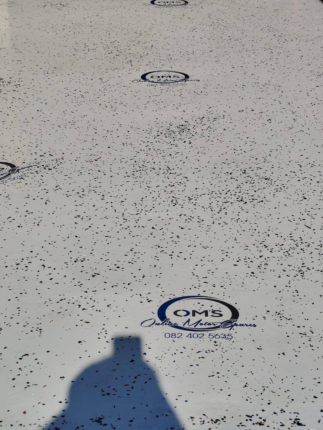 Finished epoxy flake floor with the company logo repeated along its length